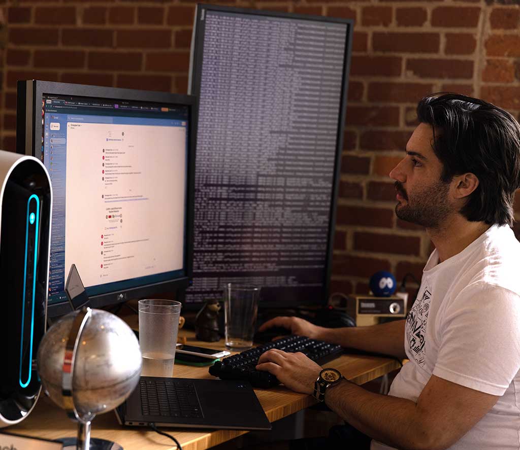 Engineer working on a computer with code on the screen.